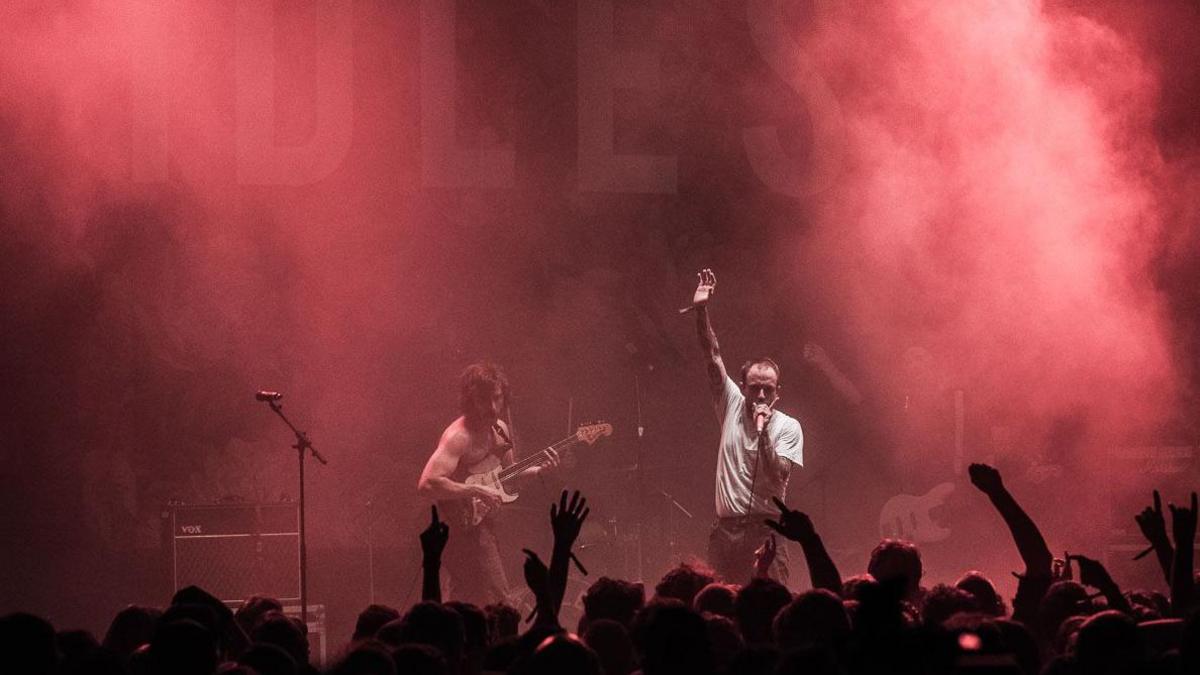 Idles performing at Simple Things with pink smoke around the stage