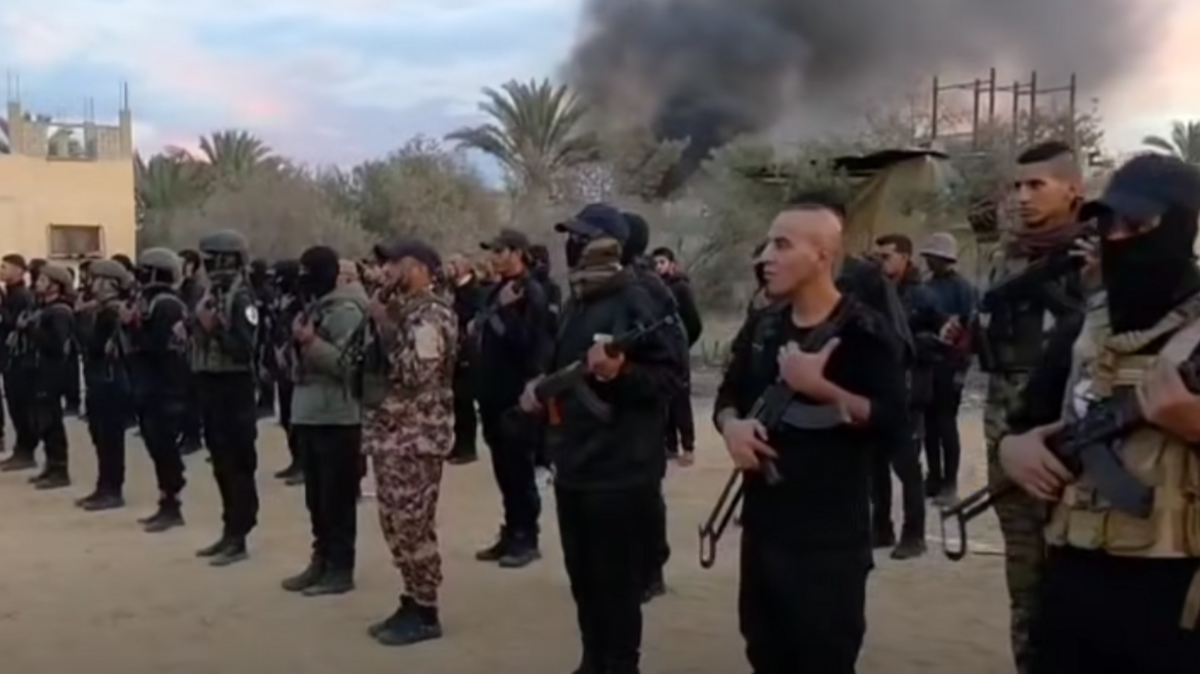 Armed members of Yasser Abu Shabab's Popular Forces militia listen to a speech by their deputy commander, Ghassan al-Dhahini (16 November 2025)
