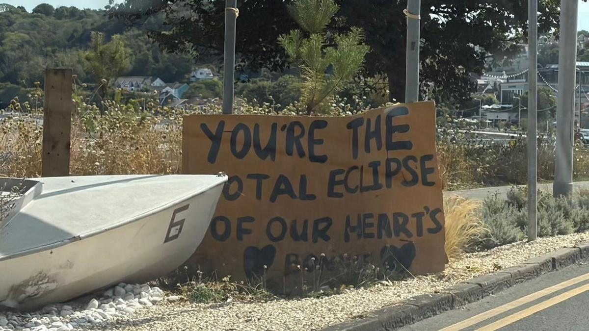 Llun o arwydd yn darllen "You're the total eclipse of our hearts Bonnie" yn y Mwmbwls. 