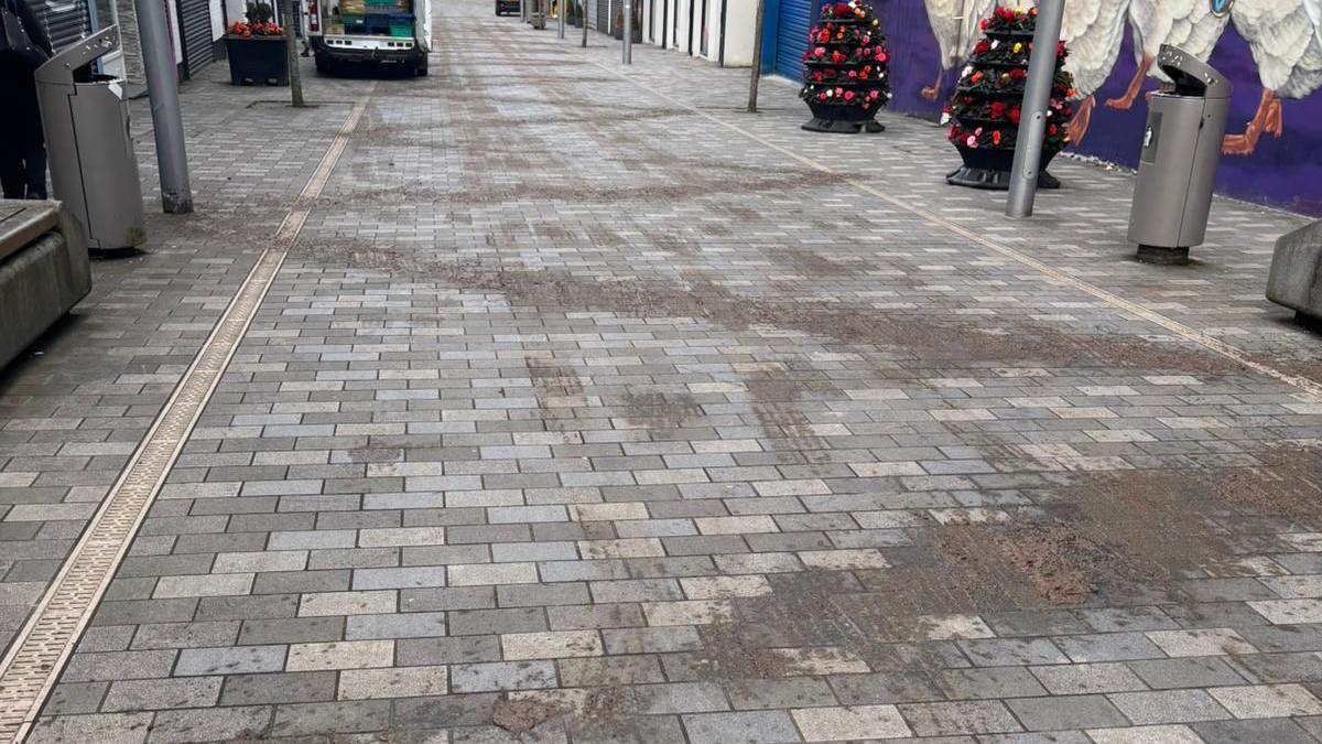 Slurry spread in a zig-zag pattern down a pedestrian street.