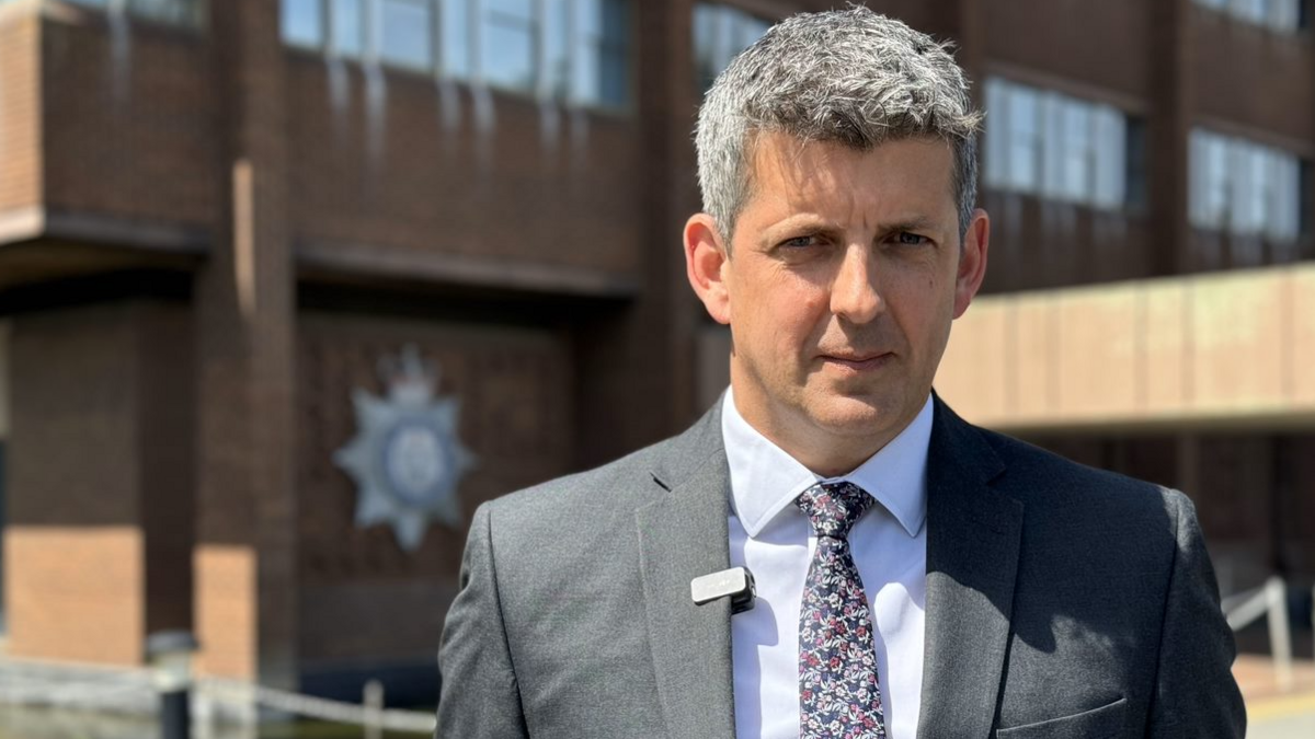 A head and shoulders image of Suffolk Police's detective inspector for the Joint Major Investigations Team, Dan Connick. He is wearing a suit and tie and looking directly into the camera.