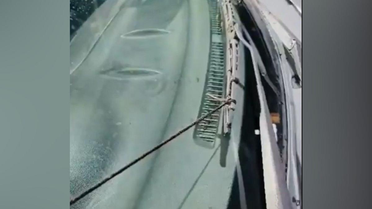 A close-up of a car windscreen and it's wipers. The closest wiper is tied to what appears to be a black shoe lace.