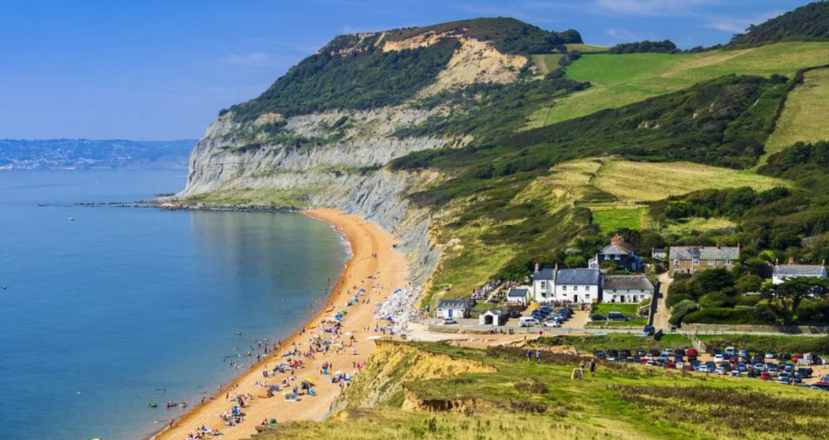 Image of a small hamlet near a sandy beach and blue sea