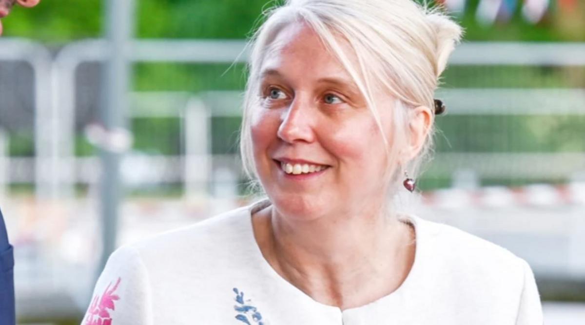 A woman with pale blonde hair and a white top looking upwards slightly