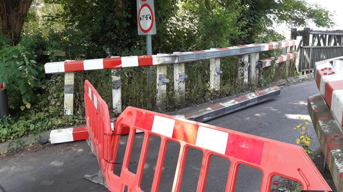 Barriers blocking the entrance to a damaged bridge