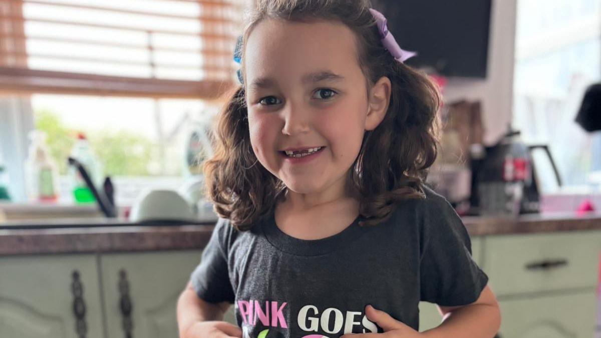 A smiling Bebe King shows off her t-shirt, which has a logo from the Wicked musical, and the caption "pink goes with green". 