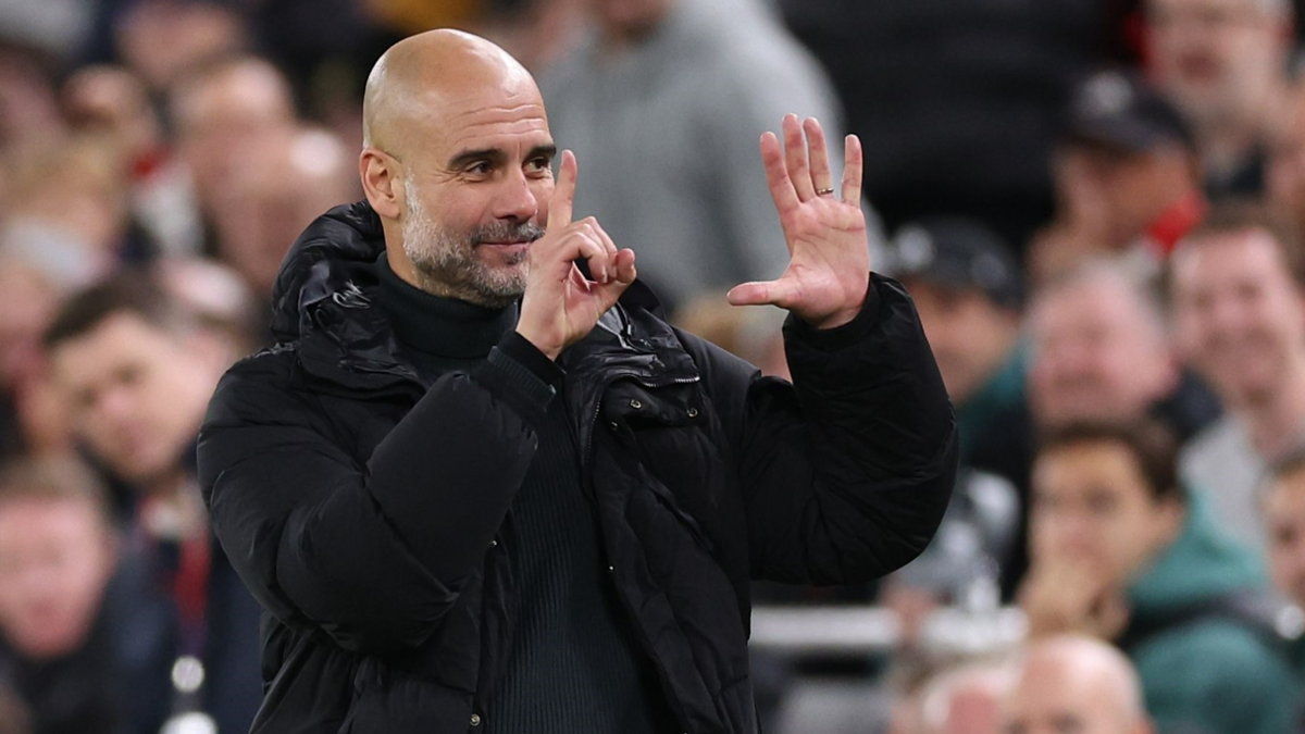 Pep Guardiola gestures to fans during Manchester City's Premier League game at Liverpool