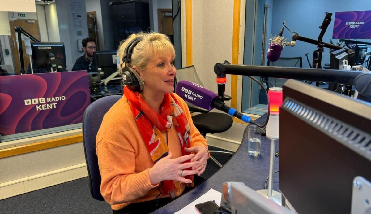 Bucks Fizz star and former Eurovision winner Cheryl Baker  sitting in font of a microphone in  a Radio Kent studio