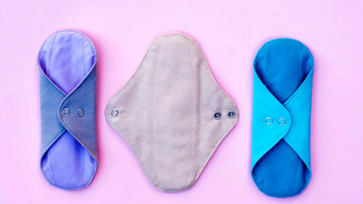 Three reusable period pads on a pink background 