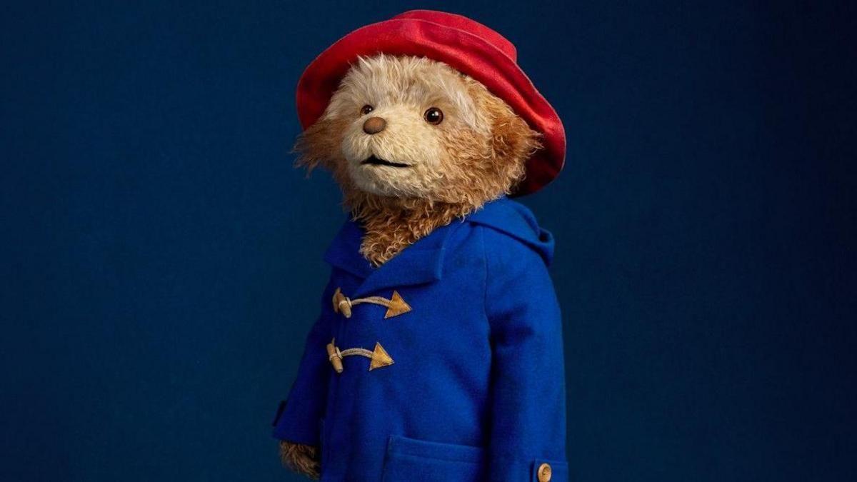 A close-up picture of Paddington from the stage show in his red hat and blue coat.