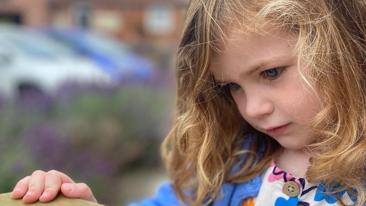 Lucy, who has cystic fibrosis, looking at something out of shot