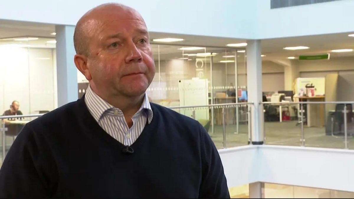 A bald man in a blue jumper