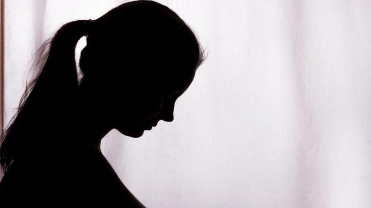 A woman can be seen in silhouette looking down in this generic photo.