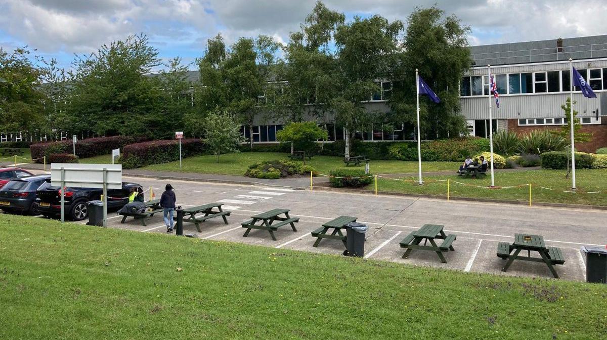 The exterior of the Beko Hotpoint Factory in Yate. There are cars parked on the left