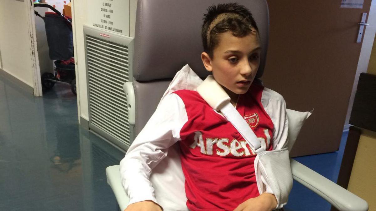 Young 13-year-old Will is sat in a hospital wheelchair, with him arm in a sling and the left side of his body paralysed.