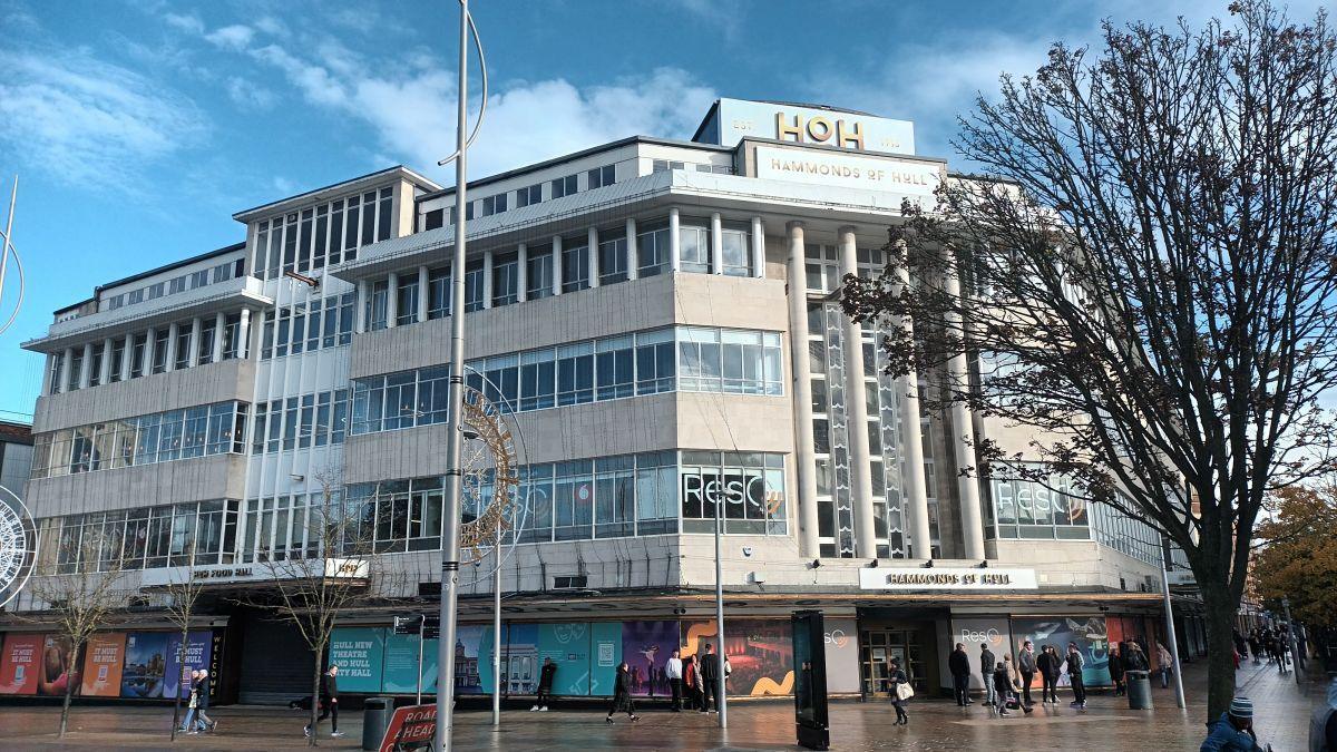 A large building in Hull city centre. It has lots of windows and is opposite Hull train station. The architecture is impressive and Hammonds of Hull is written on multiple signs, however the bottom floor os boarded up and hasn't been occupied for three years. 