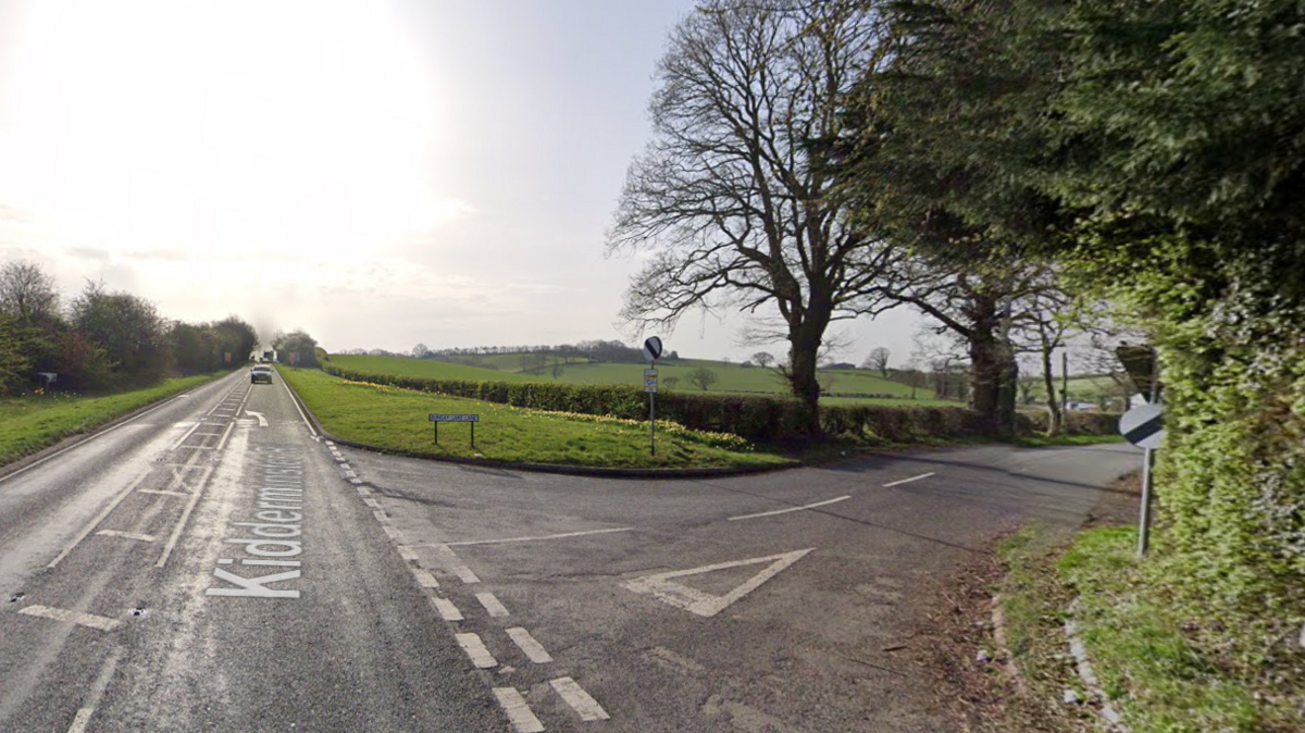 A road with a green filed in the distance 