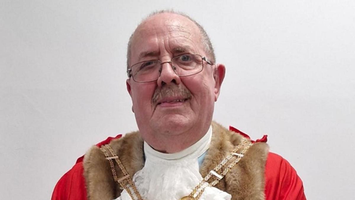 Barry Panter, a man with thinning grey hair, a moustache and glasses. He is wearing ceremonial red robes and a gold chain