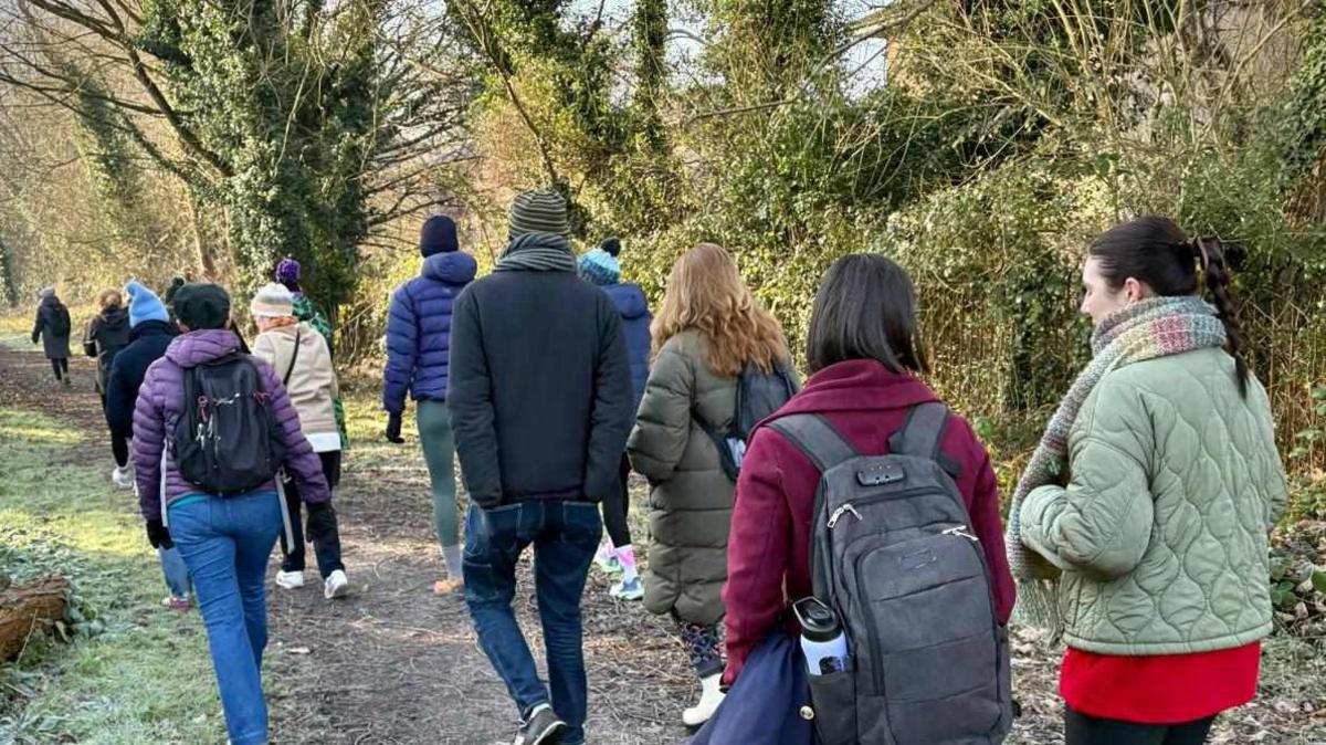 Several people walking in a wooded area for charity