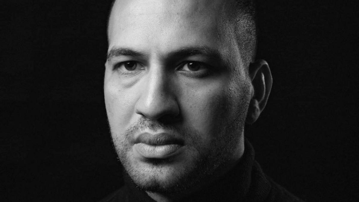 Black and white portrait photo of Mohamed Hassan. It is a head and shoulders shot of him looking at the camera.