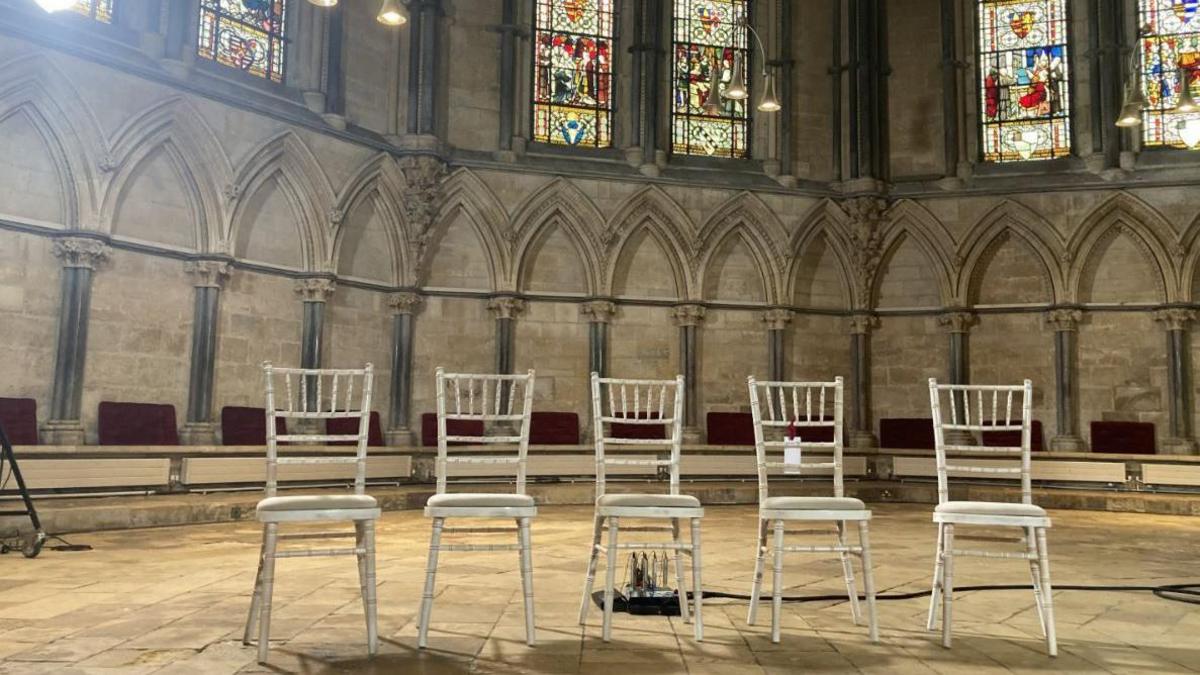 Five chairs in the foreground for the five election candidates in the interior of the Chapter House