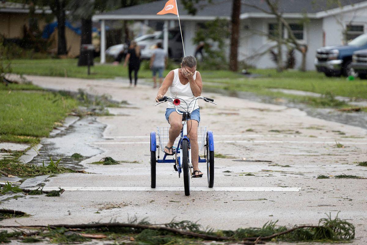 A woman cries as she rides on a tricycle after seeing the damage caused by a passing tornado as Hurricane Milton approaches Fort Myers, Florida, U.S. October 9, 2024