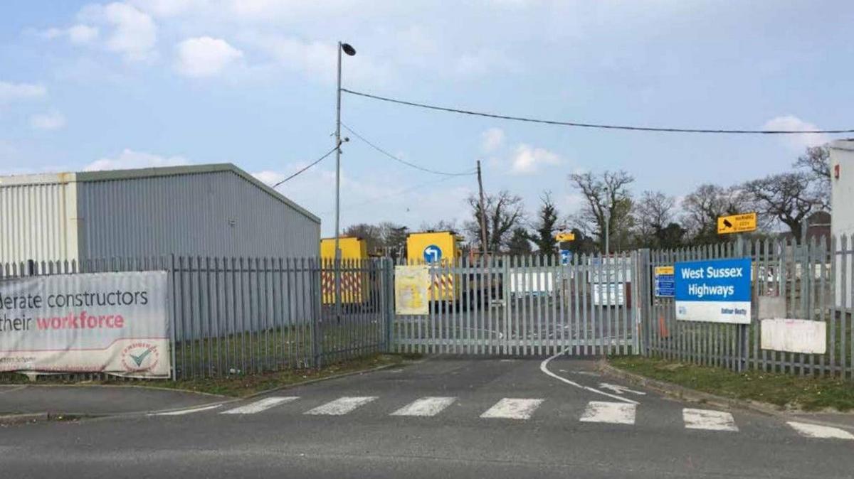 Grey fencing blocks off the entrance to a derelict lot