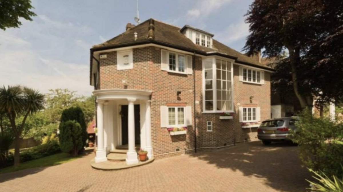 The large home in North London that Jian Wen moved into in 2017. The picture shows a three-storey house with an expansive driveway. A grey car is parked next to the house, which has multiple large windows.