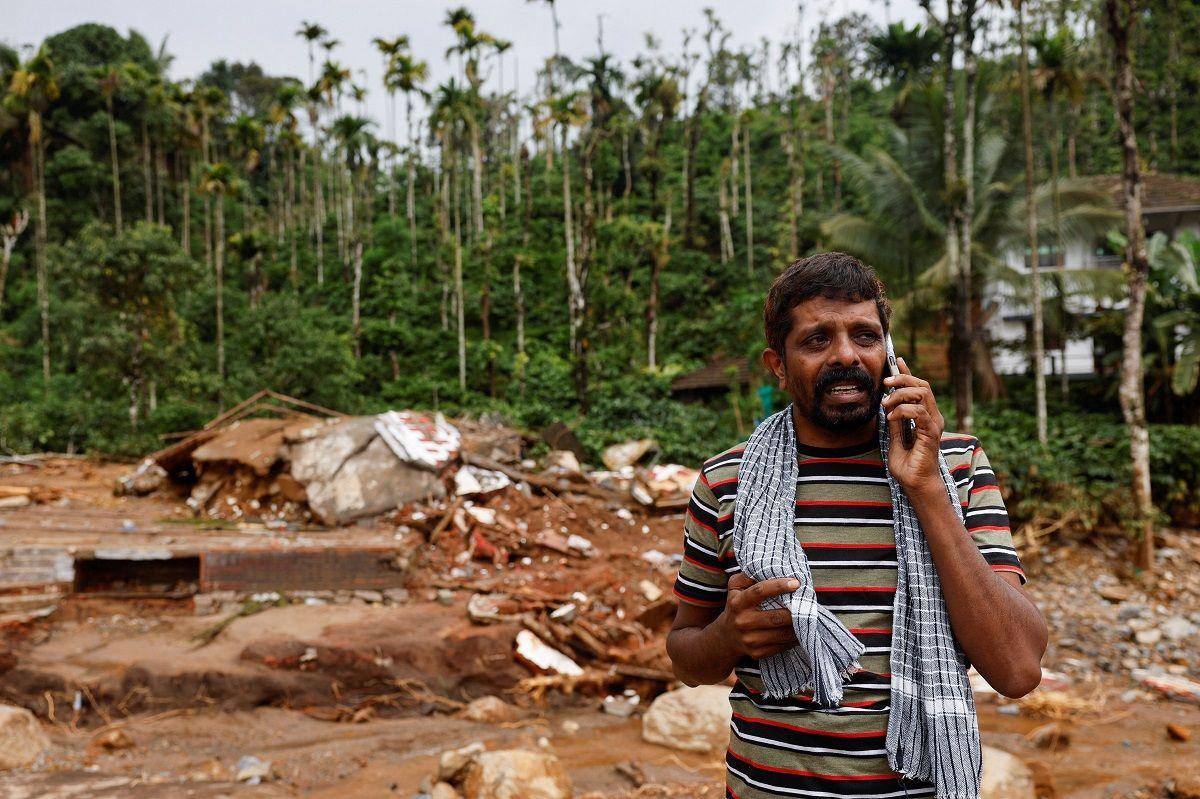 A man cries as he speaks to relatives after his home and auto rickshaw was destroyed after multiple landslides hit the hills in Wayanad