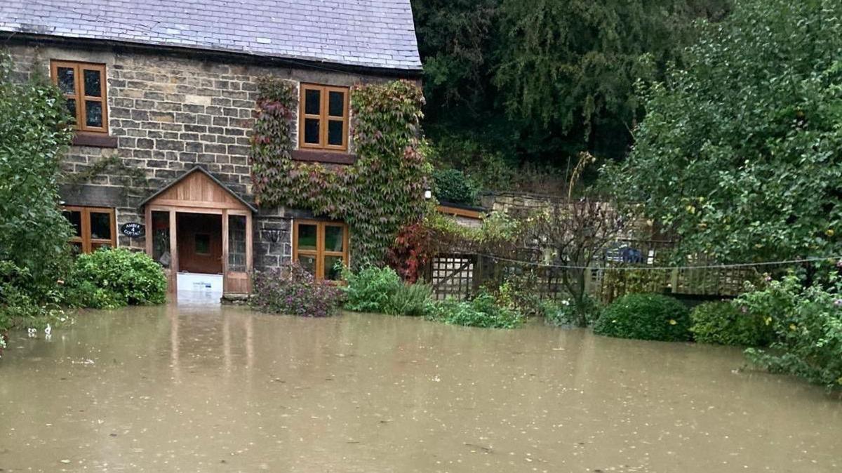 Ali Barlow's flooded home, with flood water right up to the front door