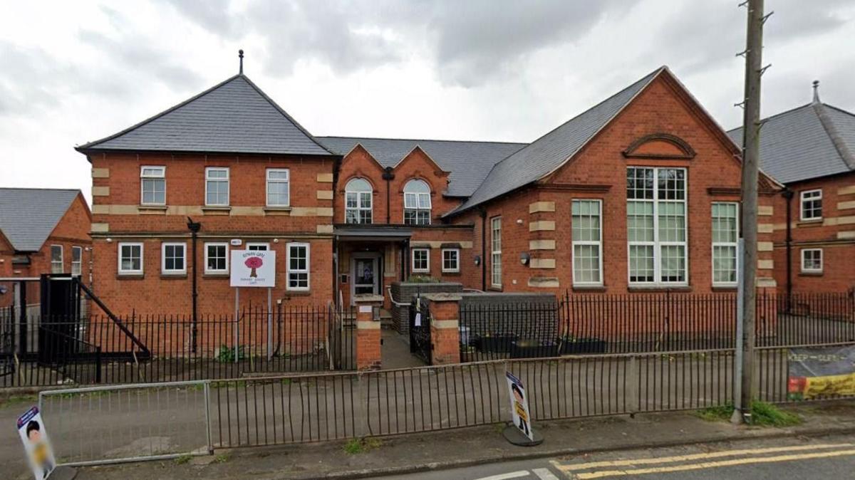 Brick-built two-storey school building with railings outside