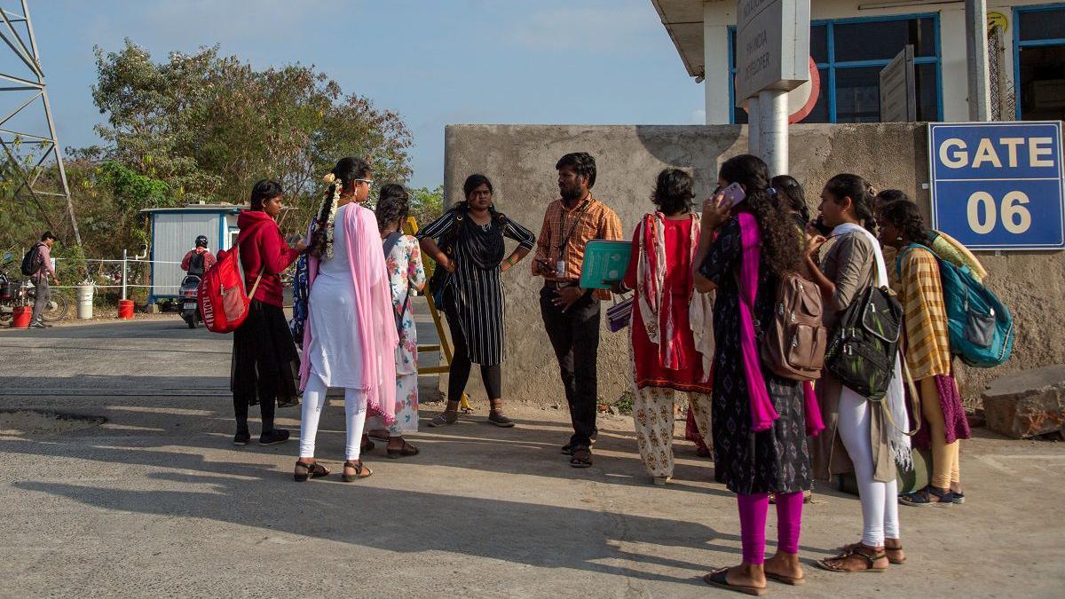 Job aspirants talk with a hiring agent outside the Foxconn factory, where workers assemble iPhones for Apple, in Sriperumbudur, near Chennai, India, April 1, 2024. REUTERS/Palani Kumar