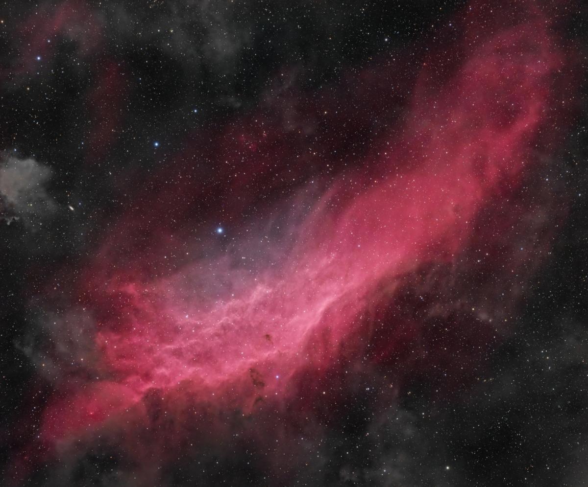 Red dust and stars against a black background. 