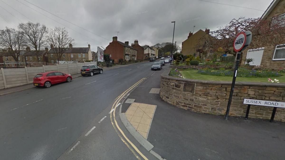 A street scene showing Lound Side to the left of the image and Sussex road on the right, with give way markings on the road in front.