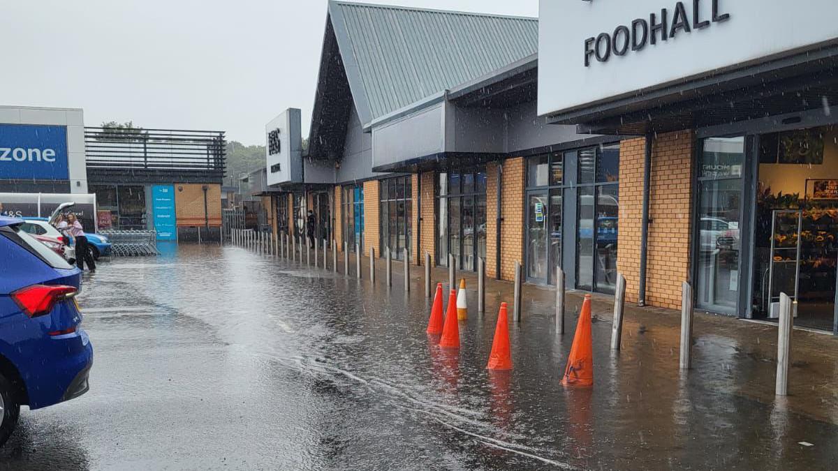 Floodwater rests outside an M&S Foodhall. Several cones have been placed in the floodwater