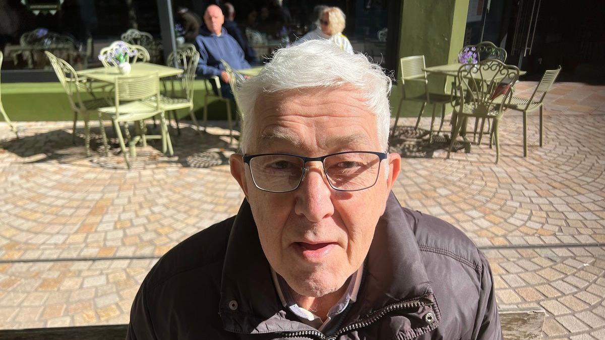 Headshot Brian Denbigh, aged 80, on a sunny day at an outdoor cafe in Altrincham