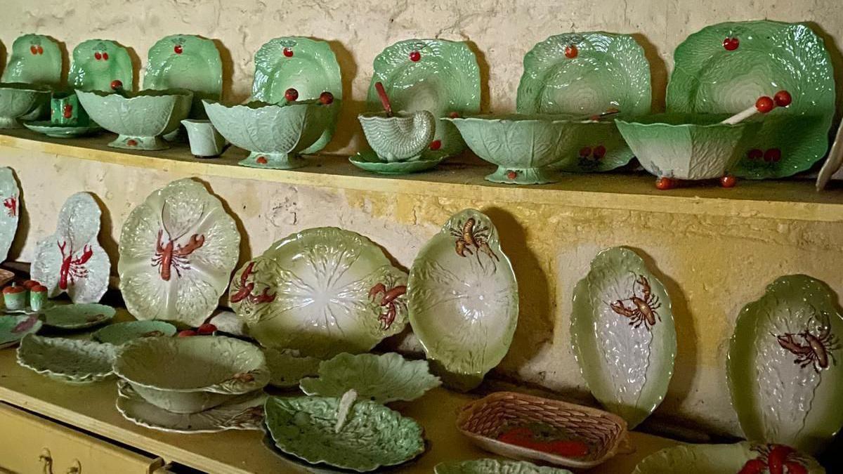 Shelves with rows of green and red plates and bowls