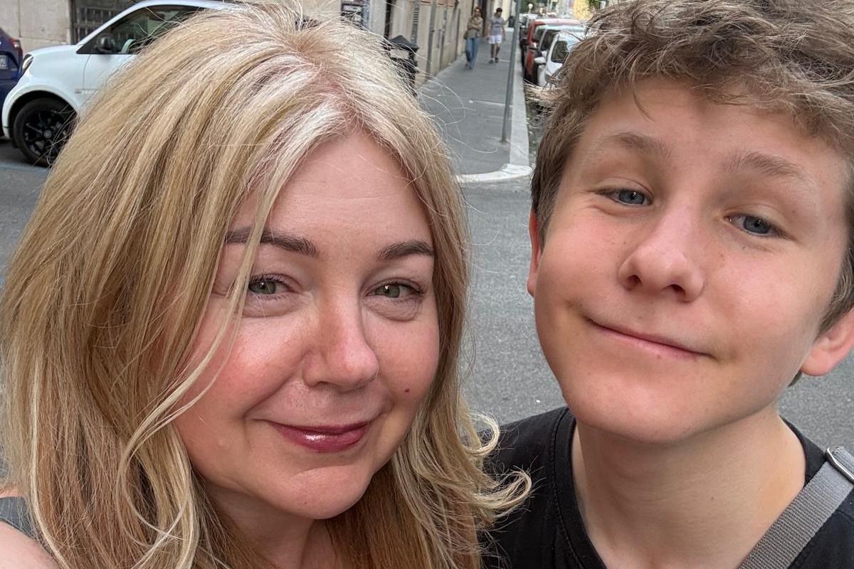 A selfie photo of lady with blonde hair and her teenage son smiling at the camera during their trip to Rome.