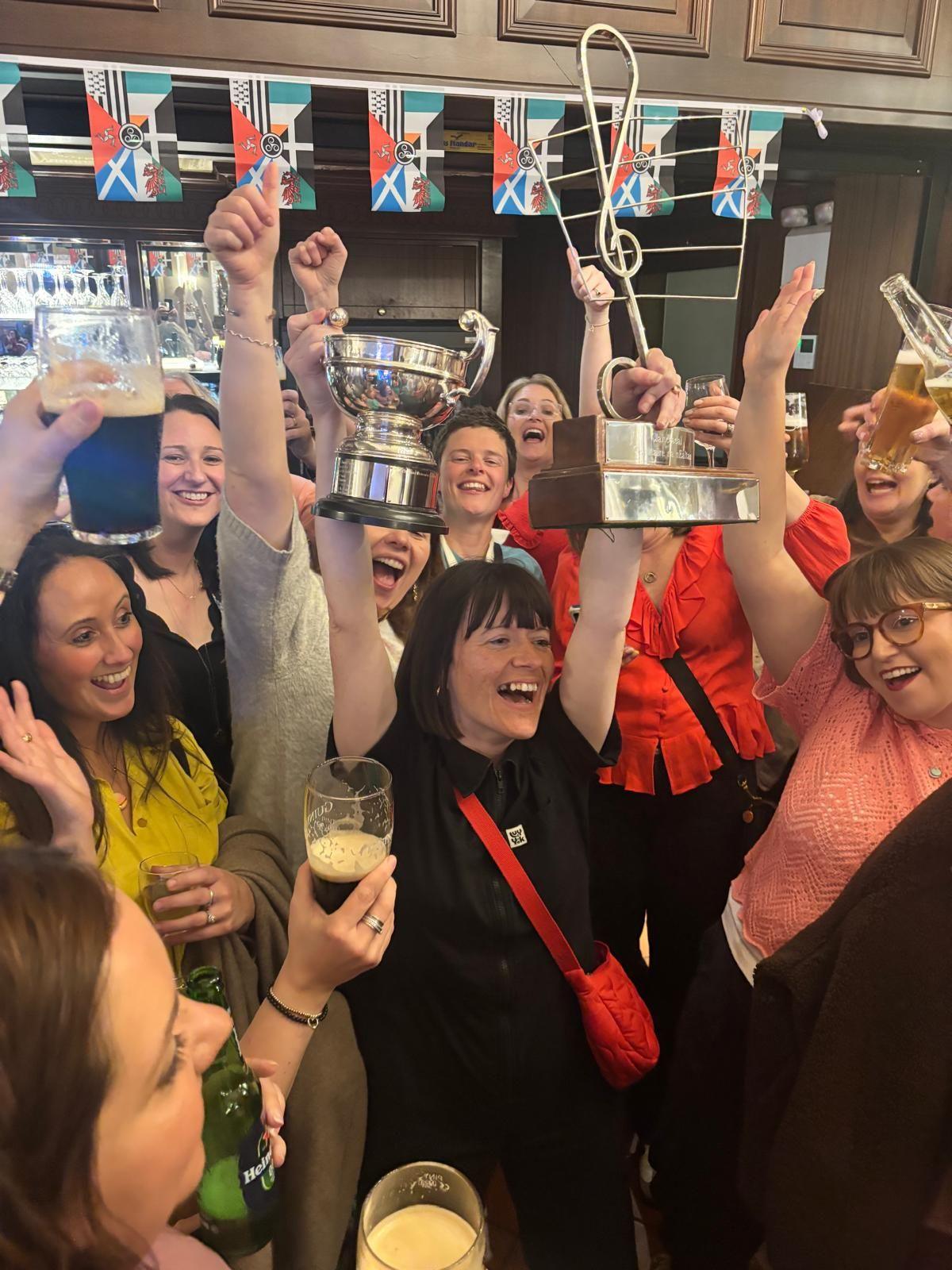 Arweinydd balch, Carys Mai yn cydio'r tlysau gydag aelodau brwd Merched Soar 