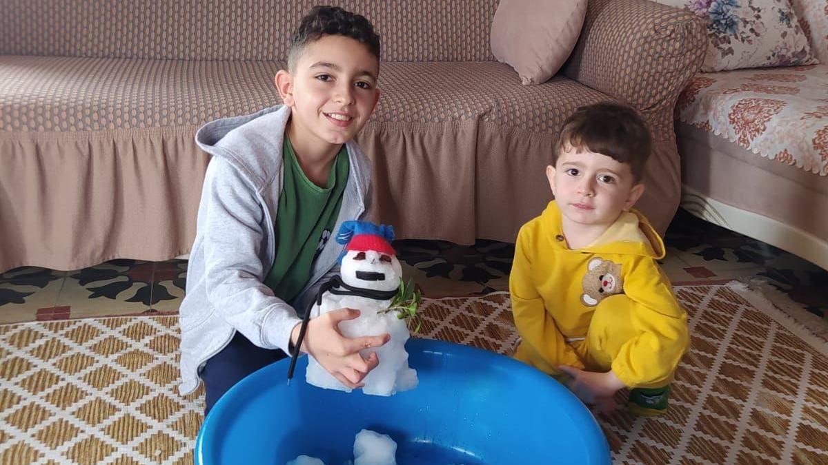 Ege and Emir making a snowman at home