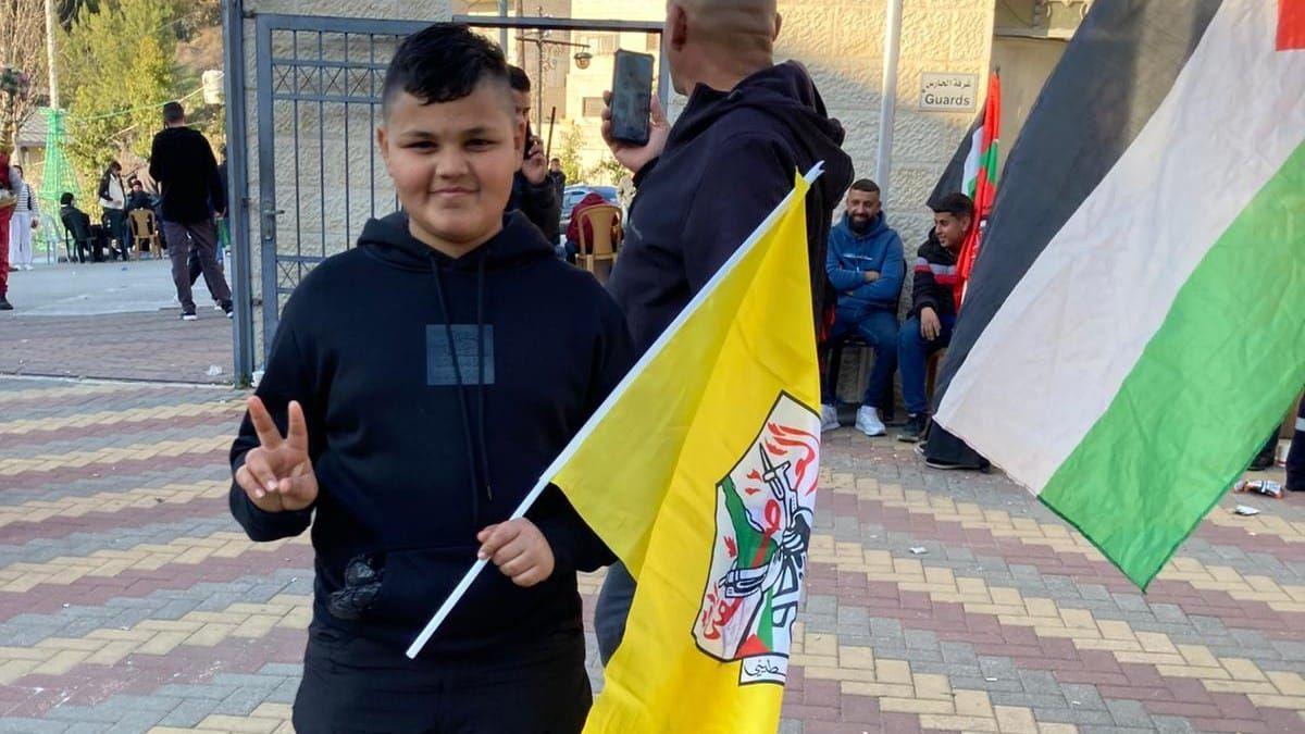 Palestinian youth holding a flag while waiting for the release of Palestinian prisoners held by Israel (30/01/25)