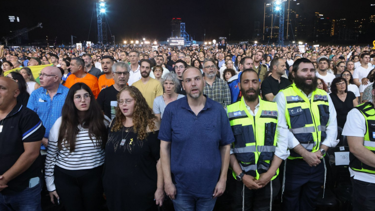 People sing as they attend an alternative memorial ceremony organized by the families of hostages held in Gaza