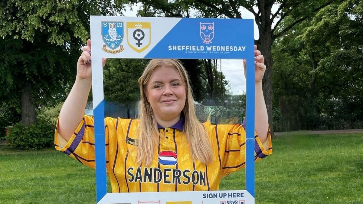 Bethany Patrick holds up promotional materials for Sheffield Wednesday Women's Supporters' Group