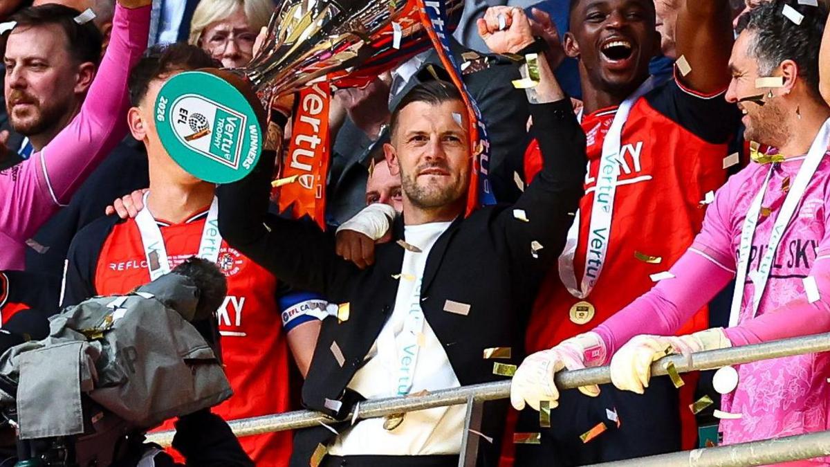 Jack Wilshere lifts the trophy and celebrates with his Luton players