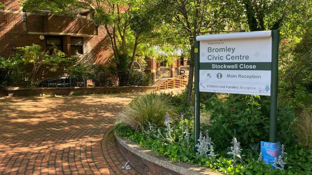 General view of the exterior of Bromley Civic Centre, a brick building with a brick path and green and white sign