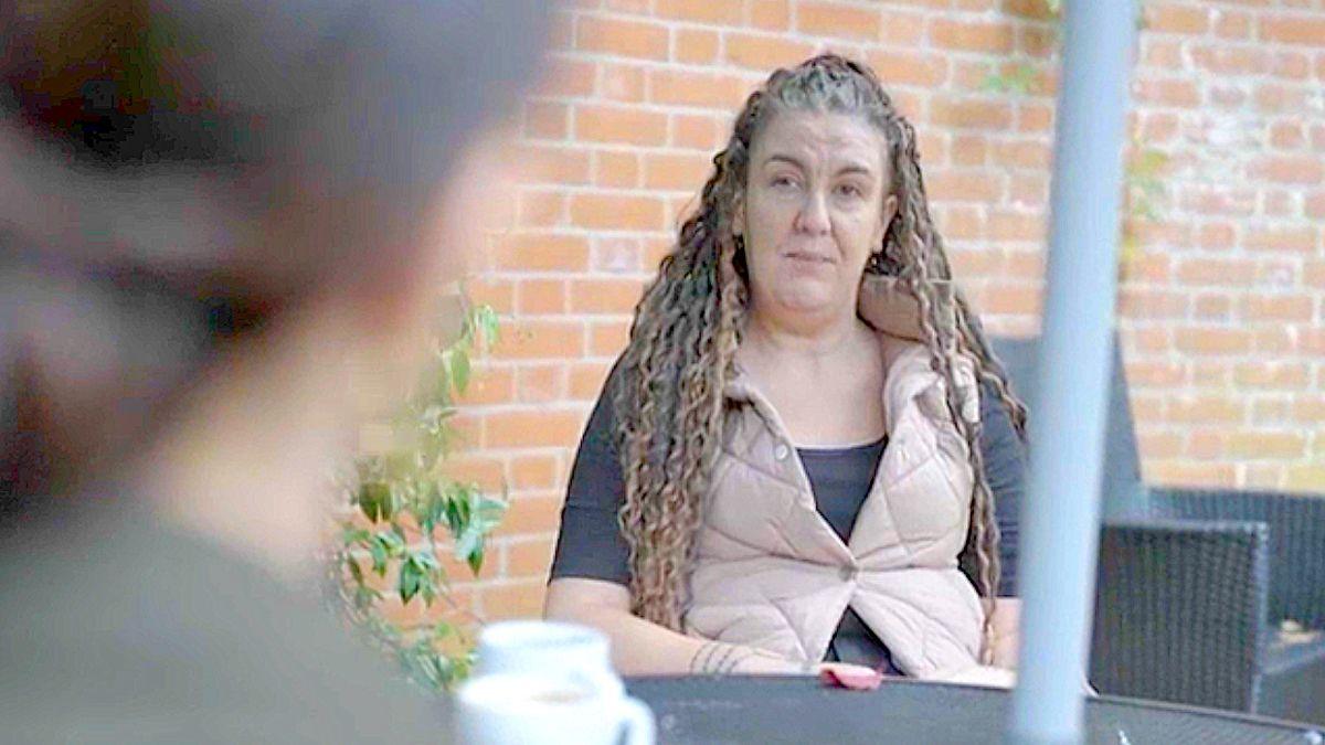 Emma Jones sits and talks to journalist Hazel from across a table outside 