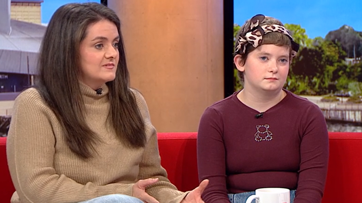 Emilia, wearing a headscarf and red top, sits next her mum in the BBC Breakfast TV studio