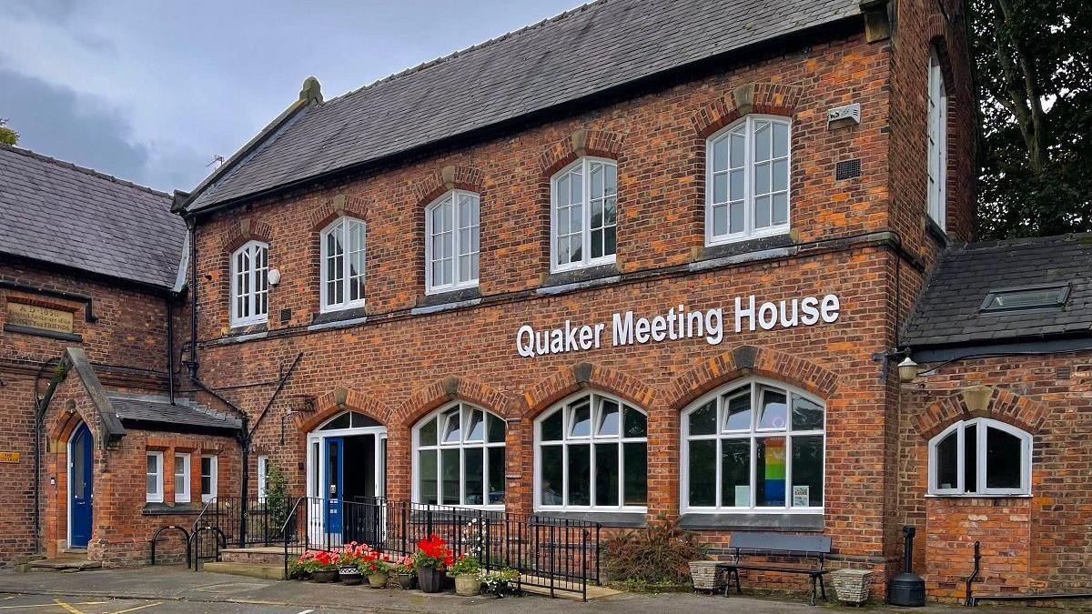 The red brick Quaker Meeting House in Sale, a two-storey building. 