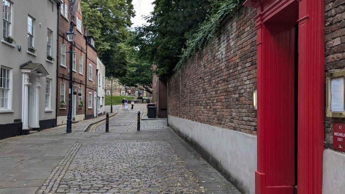 A red doorway on a cobbled side street in Nottingham