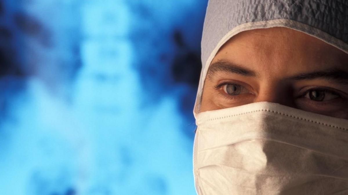 Doctor in mask with x-ray in in background